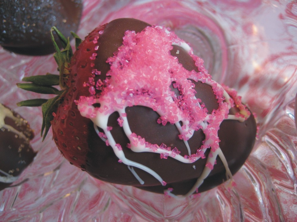 Chocolate covered strawberry with drizzle of white chocolate and pink sugar