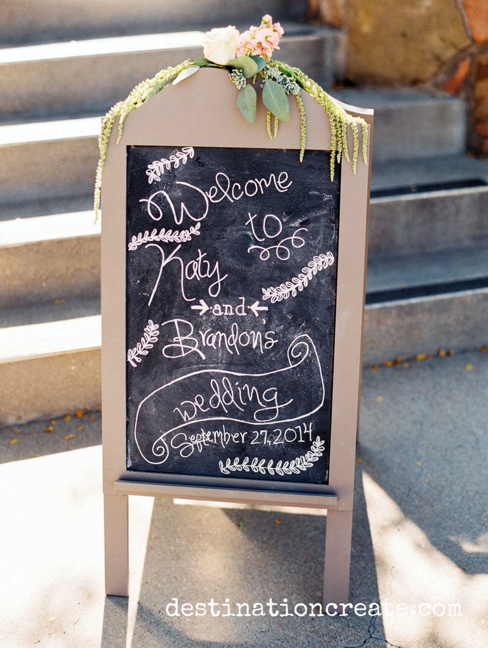 Chalkboard sign welcomes guests to romantic blush & gold wedding in Golden CO